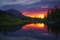 Sunrise and a chinook cloud reflected in a Bow River backwater, Bow Valley Provincial Park, Alberta, Canada
