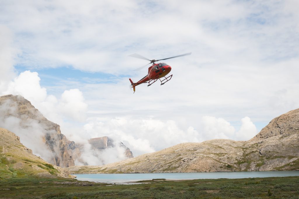The helicopter coming in for landing at lower Michelle Lakes for a pick up, Alberta, Canada