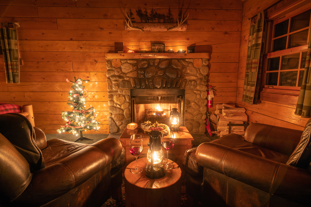 A festive indoor scene showing wine and a lit fireplace in one of the Baker creek Mountain Resort cabins.