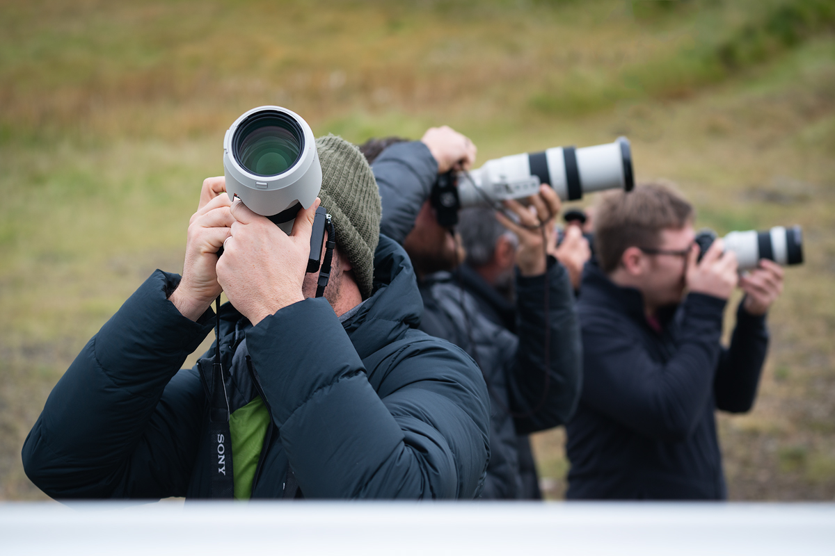 A group photo tour with photographers using their telephoto lenses to capture the distant landscape.