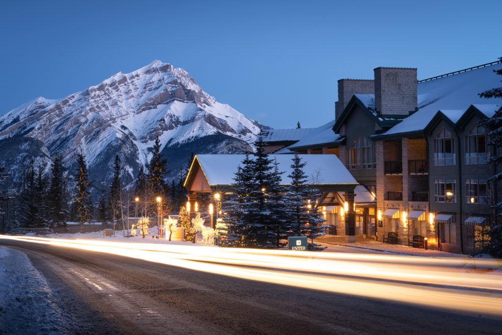The Rimrock Hotel and Cascade Mountain with traffic trails passing by the entrance. One of our banff accommodation recommendations.
